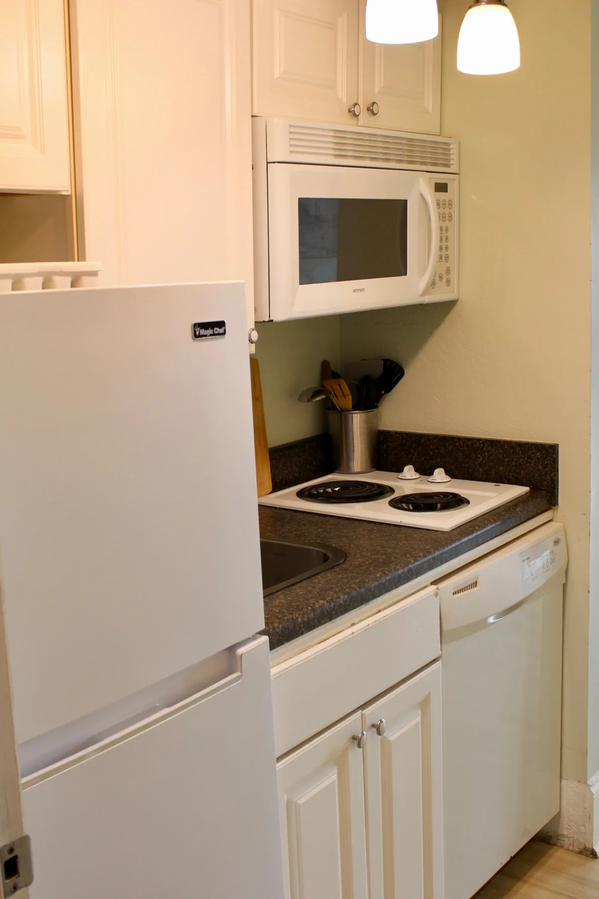 An inviting kitchen area with a refrigerator, microwave, stove, and dishwasher. The clean layout and modern appliances signal a space designed for easy meal prep and group gatherings.