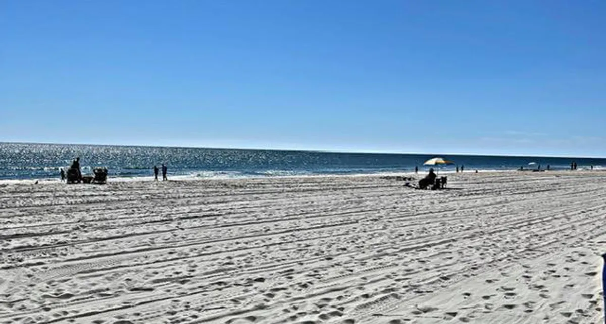 A vibrant beach scene featuring sand dunes, ocean waves, and families enjoying various seaside activities such as building sandcastles, swimming, strolling along the shore, and relaxing under beach umbrellas. The overall mood is leisurely and playful, with the beautiful Myrtle Beach shoreline in the background.